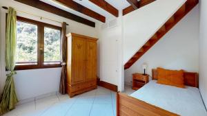 a bedroom with a bed and a window at Les Palmiers in Saint-Denis