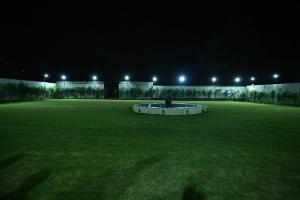 un gran campo con una fuente en el medio de la noche en Shiva Palace by Golden Leaf Hotels en Haldwāni