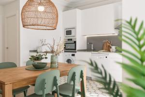 a dining room with a wooden table and green chairs at Mirador del Portillo in Zaragoza