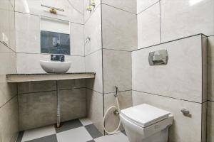 a bathroom with a toilet and a sink at FabHotel Crown Star in Dehradun
