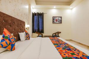 a bedroom with a large bed and a window at FabHotel Crown Star in Dehradun