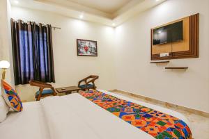 a hotel room with a bed and a tv at FabHotel Crown Star in Dehradun