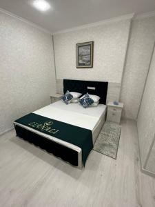 a bedroom with a bed with a black and white comforter at LIANALI Plaza in Bukhara