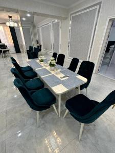 a dining table and chairs in a room at LIANALI Plaza in Bukhara