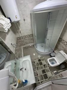 ein Badezimmer mit einem Waschbecken, einem Spiegel und einem WC in der Unterkunft LIANALI Plaza in Buxoro
