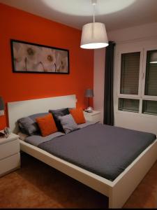 - une chambre dotée d'un lit avec un mur orange dans l'établissement 8 Beach Villas Casa Tomas, à Caleta de Fuste