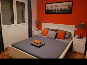 1 dormitorio con 1 cama con almohadas de color naranja en 8 Beach Villas Casa Tomas, en Caleta de Fuste