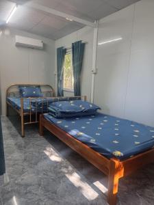2 camas individuales en una habitación con ventana en Thanh Nhi Homestay en Cam Ranh