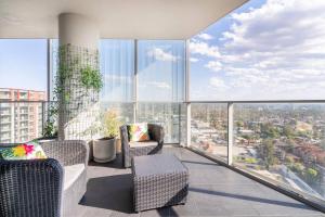 a balcony with chairs and a view of a city at The Occidental Pearl in Sydney