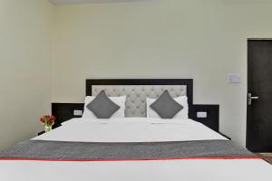 ein Schlafzimmer mit einem großen Bett mit weißer Bettwäsche und Kissen in der Unterkunft Collection O Hotel Starfield in Lucknow