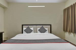 ein Schlafzimmer mit einem großen weißen Bett mit grauen Kissen in der Unterkunft Collection O Hotel Starfield in Lucknow