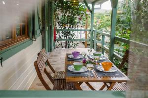 una mesa de madera con platos de comida en un porche en Domaine Babwala, villa et bungalow avec piscine dans un superbe jardin tropical #cosy en Saint-Louis