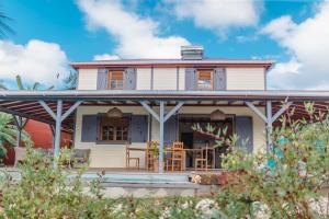 Casa blanca con porche y sillas en Domaine Babwala, villa et bungalow avec piscine dans un superbe jardin tropical #cosy en Saint-Louis