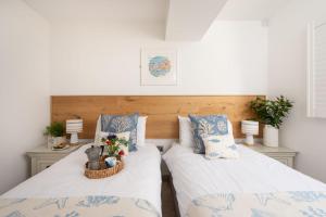 2 camas en una habitación con almohadas blancas y azules en St Ia, Castle Approach, Tregenna Castle, en St Ives