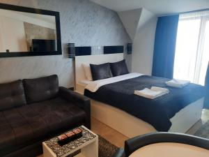 um quarto de hotel com uma cama e um sofá em Milmari P79 em Kopaonik