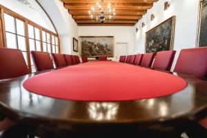 a conference room with a table and red chairs at Grad Strmol in Cerklje na Gorenjskem