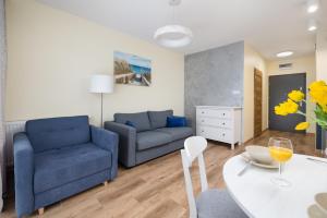 a living room with a blue couch and a table at Modern Studio in Resort & SPA Dziwnów by Renters in Dziwnów