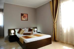 a bedroom with a bed and a large window at Calla Inn Hotel in Constanţa