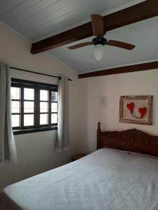 um quarto com uma cama e uma ventoinha de tecto em Pousada Lírio do Campo em São Pedro da Serra
