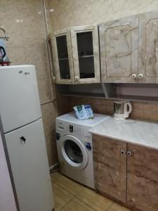 a kitchen with a washing machine and a refrigerator at Guesthouse Kato in Tbilisi City