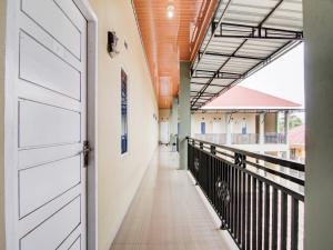 un couloir d'un immeuble avec une porte et un couloir dans l'établissement OYO 93087 Wisma Apel Syariah, à Parit