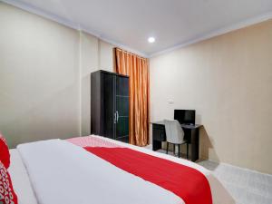 A bed or beds in a room at OYO 93087 Wisma Apel Syariah