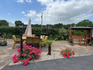 patio ze stołem, krzesłami i kwiatami w obiekcie Idyllic getaway in countryside w mieście Clonmel