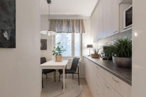 a kitchen with a white table and chairs and a window at Tunnelmallinen kaksio in Jyväskylä