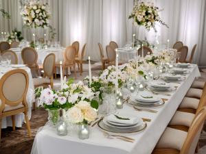 a long table with white flowers in a room at The Westin London City in London