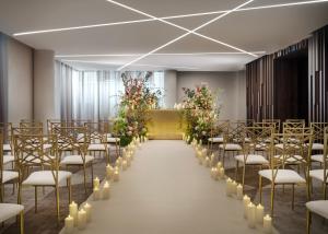 una fila de sillas en una habitación con flores y velas en The Westin London City, en Londres