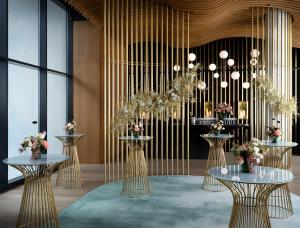 a lobby with two tables and a chandelier at The Westin London City in London