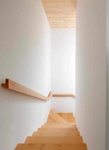 a staircase in a room with white walls and wooden floors at El Balcón del Sueve in Melarde