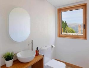 a bathroom with a white toilet and a window at El Balcón del Sueve - Naturaleza y vistas in Melarde +16 photos