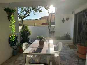 a table and chairs on a patio with plants at Cascais Quaint Cottage in Alcabideche