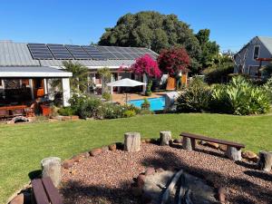 a garden with a bench and a swimming pool at Marula Lodge in Swellendam