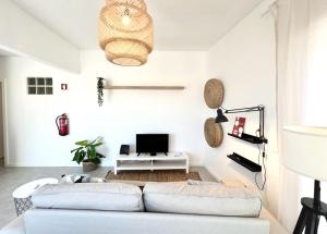 a living room with two white couches and a television at Casa Diogo in Faro