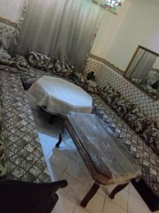 Appartement avec piscine.mikki beach في طنجة: غرفة بسرير ومقعد وطاولة