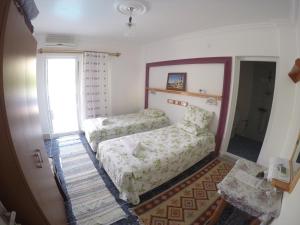 a bedroom with a bed and a chair and a mirror at Rose Hotel B&B in Patara