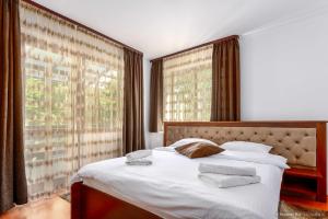 1 dormitorio con 1 cama con 2 toallas en Elim Residence en Mănăstirea Humorului
