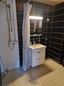 a bathroom with a sink and a shower curtain at Stylish apartment in town centre in Sotkamo