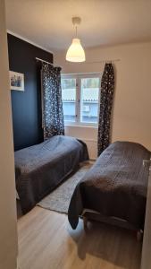 1 dormitorio con 2 camas y ventana en Stylish apartment in town centre, en Sotkamo