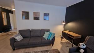 a living room with a couch and a piano at Stylish apartment in town centre in Sotkamo