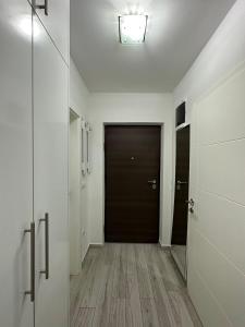 - un couloir avec une porte noire et du parquet dans l'établissement Nelly, à Sarajevo