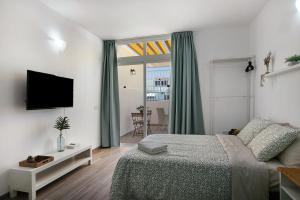 Un dormitorio con una cama y un televisor en una pared. en Estudio Sagrario, en Arona 15 fotos más