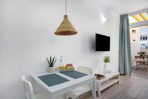 una mesa blanca y sillas en una habitación con TV en Estudio Sagrario, en Arona