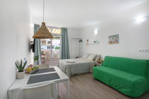 sala de estar con sofá verde y cama en Estudio Sagrario, en Arona