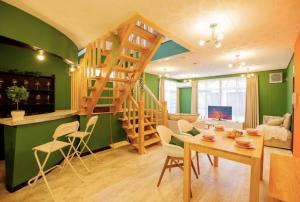 a living room with a staircase and a table and chairs at Yuzawa Onsen Lodge 1min to LIFT House in Seki