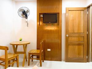 a room with a door and a table and a television at Dreaming Forest Hotel - Libjo, Batangas in Batangas City