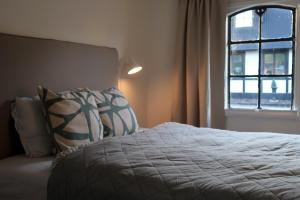 1 dormitorio con cama con almohadas y ventana en Cosy guesthouse in the countryside, with breakfast, en Malmö