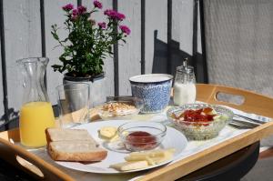 a wooden table with a plate of food on it at Cosy guesthouse in the countryside, with breakfast in Malmö